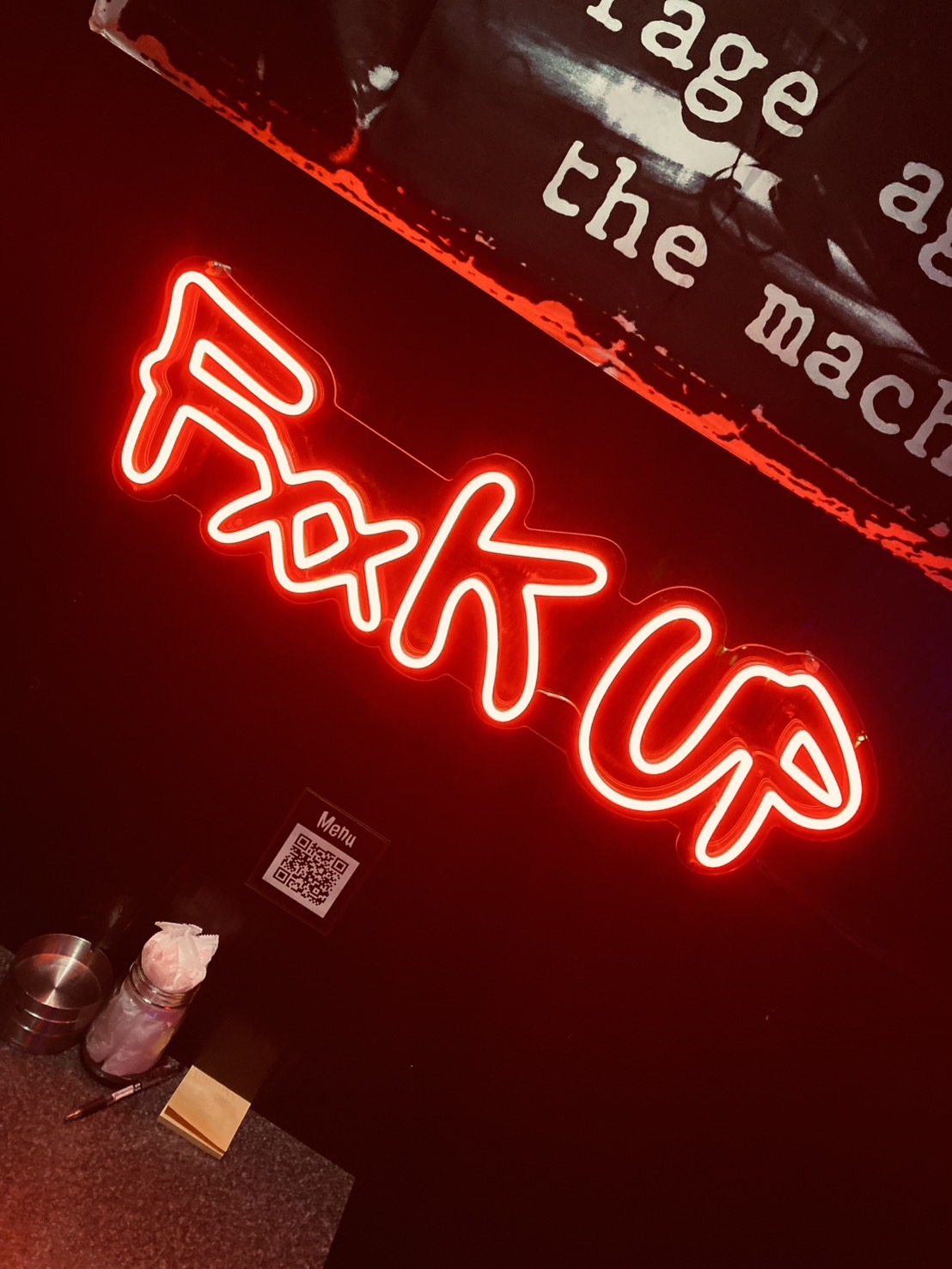 The red FxxK Up neon sign glowing inside the bar